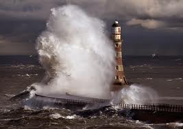 A Lighthouse manages to stand tall even tossed about in a stormy sea.
